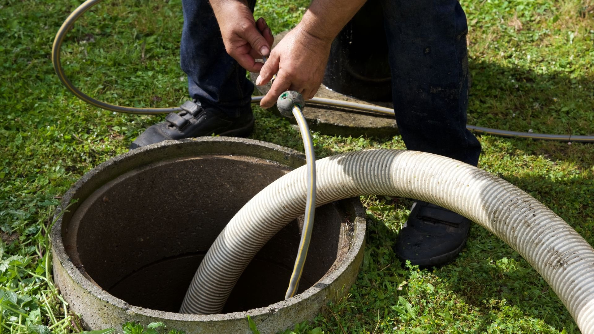 Inserting corrugated hose into a concrete septic tank opening