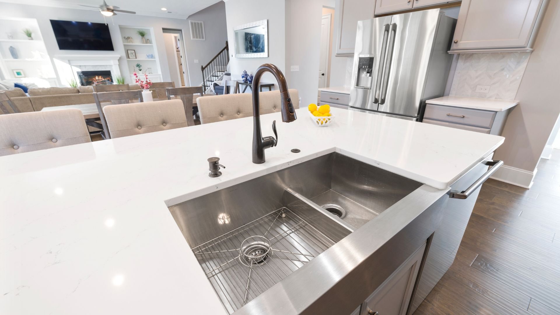 Modern kitchen with white countertops, stainless steel sink, and black faucet