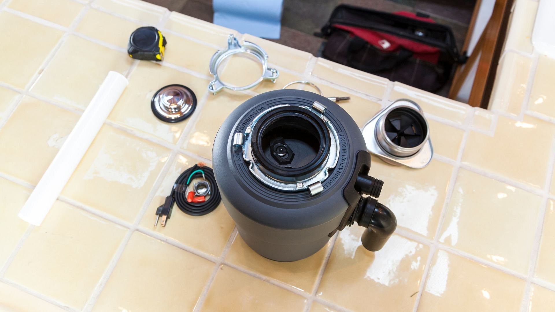Disassembled camera lens with accessories on tiled surface