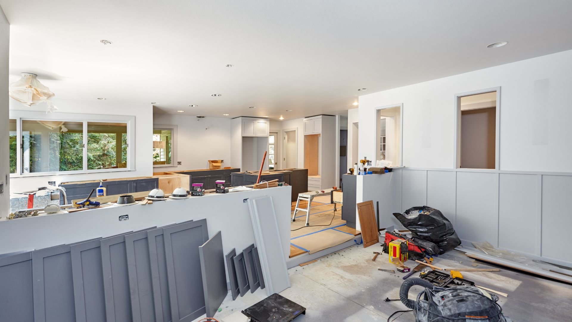 Kitchen renovation in progress with construction tools and materials scattered around