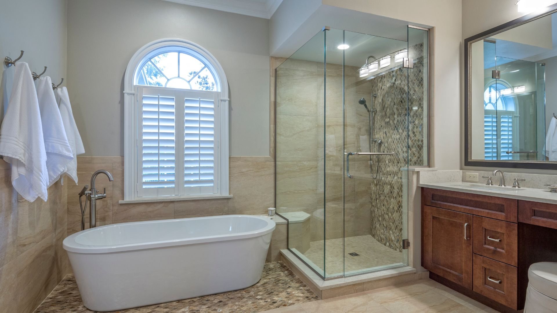 Elegant bathroom with freestanding tub, glass shower, and wooden vanity