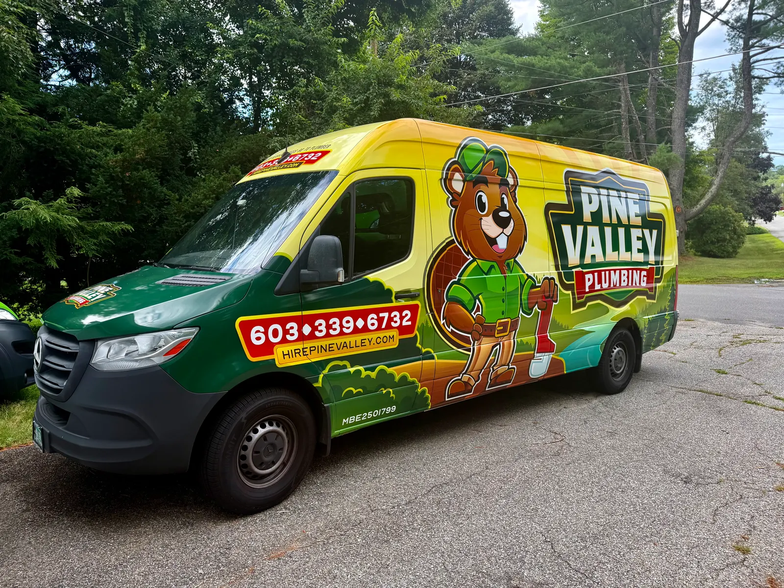 Pine Valley Plumbing truck with beaver mascot wrap parked on a sunny New Hampshire street